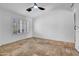 Neutral room featuring tiled flooring, one window with plantation shutters, and a ceiling fan at 5320 W Soft Wind Dr, Glendale, AZ 85310