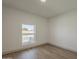 A bedroom with gray wood-look flooring and a window looking out to the yard at 727 N Beverly --, Mesa, AZ 85201
