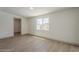 Bright, airy bedroom featuring a large window, modern flooring, and an open doorway to another room at 727 N Beverly --, Mesa, AZ 85201