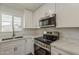 Modern kitchen featuring stainless steel appliances, including a stove and a microwave, complemented by white countertops and cabinets at 727 N Beverly --, Mesa, AZ 85201