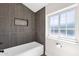 Bathroom featuring a window next to a bathtub and modern gray tiles at 856 W Quail Cir, San Tan Valley, AZ 85143
