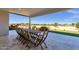 Covered patio featuring an outdoor dining area with a large table and views of lush landscaping at 856 W Quail Cir, San Tan Valley, AZ 85143