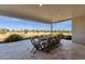 Covered patio featuring an outdoor dining area with a large table and views of lush landscaping at 856 W Quail Cir, San Tan Valley, AZ 85143