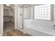 Bright bathroom features hard surface floors, clear shower door and block window over large tub at 1073 N 159Th Dr, Goodyear, AZ 85338