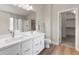 Bathroom with double sink vanity, decorative mirror lights, hard surface floors and walk-in closet at 1073 N 159Th Dr, Goodyear, AZ 85338