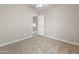Bright bedroom with neutral walls, carpet, and view into hallway at 1073 N 159Th Dr, Goodyear, AZ 85338