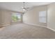 Large bedroom with neutral carpet, ceiling fan, vaulted ceiling, and view of neighborhood from window at 1073 N 159Th Dr, Goodyear, AZ 85338