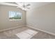Bright bedroom features neutral walls, carpet, a ceiling fan, and a window at 1073 N 159Th Dr, Goodyear, AZ 85338