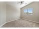 Light filled room with neutral walls and carpet, ceiling fan and a bright window at 1073 N 159Th Dr, Goodyear, AZ 85338
