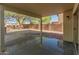 Covered patio offers shade with view of backyard, mature trees and block fence at 1073 N 159Th Dr, Goodyear, AZ 85338