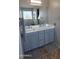 This bathroom features a double sink vanity with gray cabinets, marble countertops, and a large mirror at 1075 E Crimm Rd, San Tan Valley, AZ 85143