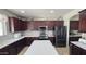 Modern kitchen boasting dark wood cabinets, stainless steel appliances, and a large island at 1075 E Crimm Rd, San Tan Valley, AZ 85143