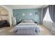 This main bedroom features an accent wall, bedside tables, decor shelves, an upholstered bench, and natural light from the window at 1075 E Crimm Rd, San Tan Valley, AZ 85143