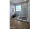 This bright shower features marble walls, a frameless glass door, a rain shower head, and a bench outside the shower at 1075 E Crimm Rd, San Tan Valley, AZ 85143