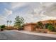 Charming house with a two-car garage, desert landscaping, and palm trees on a sunny day at 10830 N 11Th St, Phoenix, AZ 85020