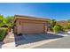 A view of the two car garage, with a tile roof and desert landscaping surrounding the exterior at 10830 N 11Th St, Phoenix, AZ 85020