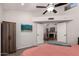 Bright main bedroom featuring ceiling fan, closet and french doors leading to the living room with fireplace at 10830 N 11Th St, Phoenix, AZ 85020