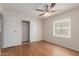 This bedroom offers wood floors, a ceiling fan, closet space, and a window at 11275 N 99Th Ave # 1, Peoria, AZ 85345