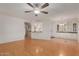 Bright living room featuring wood floors, a ceiling fan, and an open view of the kitchen at 11275 N 99Th Ave # 1, Peoria, AZ 85345