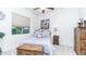 A cozy bedroom with a metal framed bed, a decorative chest, and a window with blinds at 11307 E Elmhurst Dr, Chandler, AZ 85249