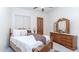 A traditional bedroom with a wooden bed frame, dresser, and a window with blinds at 11307 E Elmhurst Dr, Chandler, AZ 85249