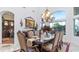 Elegant dining room featuring a large window, a chandelier, and a decorative table at 11307 E Elmhurst Dr, Chandler, AZ 85249