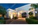 Picturesque porte cochere with stone columns, beautiful landscaping, and warm exterior lighting at 11307 E Elmhurst Dr, Chandler, AZ 85249