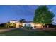 Elegant home exterior at twilight with manicured lawn, a large shade tree, and a circular driveway leading to the entrance at 11307 E Elmhurst Dr, Chandler, AZ 85249
