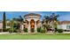 Elegant home featuring a grand entrance, well-manicured lawn, and lush landscaping at 11307 E Elmhurst Dr, Chandler, AZ 85249