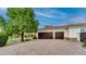 Spacious three-car garage with dark wood doors and well-manicured landscaping in a charming setting at 11307 E Elmhurst Dr, Chandler, AZ 85249