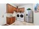 Laundry room featuring stainless steel appliances, a sink, ample cabinet space, and a tiled floor at 11307 E Elmhurst Dr, Chandler, AZ 85249