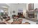 Comfortable living room featuring a stone fireplace, plush seating, and bright lighting at 11307 E Elmhurst Dr, Chandler, AZ 85249