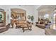 Bright living room with traditional brown sofas, a round glass table, and an open floorplan with access to the kitchen at 11307 E Elmhurst Dr, Chandler, AZ 85249
