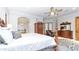 Elegant main bedroom with hardwood furniture, a ceiling fan, and an open doorway to a spa-like bathroom at 11307 E Elmhurst Dr, Chandler, AZ 85249