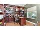 Home office featuring custom built-in shelving, a desk, a comfortable chair, and a sunlit window at 11307 E Elmhurst Dr, Chandler, AZ 85249
