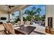 A covered patio with an outdoor dining table overlooking the beautiful backyard pool and landscaping at 11307 E Elmhurst Dr, Chandler, AZ 85249