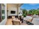 Covered patio with comfortable seating, TV, and a view of the lush backyard and pool area at 11307 E Elmhurst Dr, Chandler, AZ 85249