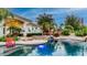 A backyard pool with a waterfall, spa, lush landscaping, and plenty of space for outdoor seating at 11307 E Elmhurst Dr, Chandler, AZ 85249