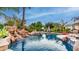 Beautiful pool with a rock waterfall feature, palm trees, and basketball hoop at 11307 E Elmhurst Dr, Chandler, AZ 85249