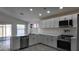 Updated kitchen with sleek white cabinets, stainless appliances and gray wood-look flooring at 11342 W Barbara Ave, Peoria, AZ 85345