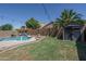 Beautiful backyard featuring a pool, a shed, a pergola, and green grass at 11832 W Electra Ln, Sun City, AZ 85373