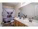 Bright bathroom featuring a double sink vanity, large mirror, and a funny cow shower curtain at 11832 W Electra Ln, Sun City, AZ 85373