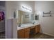 Bathroom with double sink vanity, tile flooring, large mirror, and a walk-in closet on the side at 11832 W Electra Ln, Sun City, AZ 85373