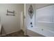 Bright bathroom features a soaking tub, shower with curtain, decorative wall art, and a window at 11832 W Electra Ln, Sun City, AZ 85373