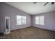 Light filled primary bedroom with neutral carpet, light purple walls, and bright windows at 11832 W Electra Ln, Sun City, AZ 85373