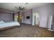 Spacious bedroom featuring a king bed, ceiling fan, walk in closet, and entry to a bathroom at 11832 W Electra Ln, Sun City, AZ 85373