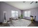 Bedroom with light purple walls, two chairs, a mirror and an exercise bike at 11832 W Electra Ln, Sun City, AZ 85373