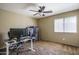 Bedroom with a ceiling fan, carpet, and a bright window, set up as a functional workspace at 11832 W Electra Ln, Sun City, AZ 85373