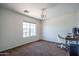 Bright bedroom with carpet, a chandelier, a window, and a desk, offering a versatile and well-lit space at 11832 W Electra Ln, Sun City, AZ 85373