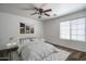 Relaxing bedroom showcasing a ceiling fan, neutral carpet, and a bright window, designed for tranquility and comfort at 11832 W Electra Ln, Sun City, AZ 85373